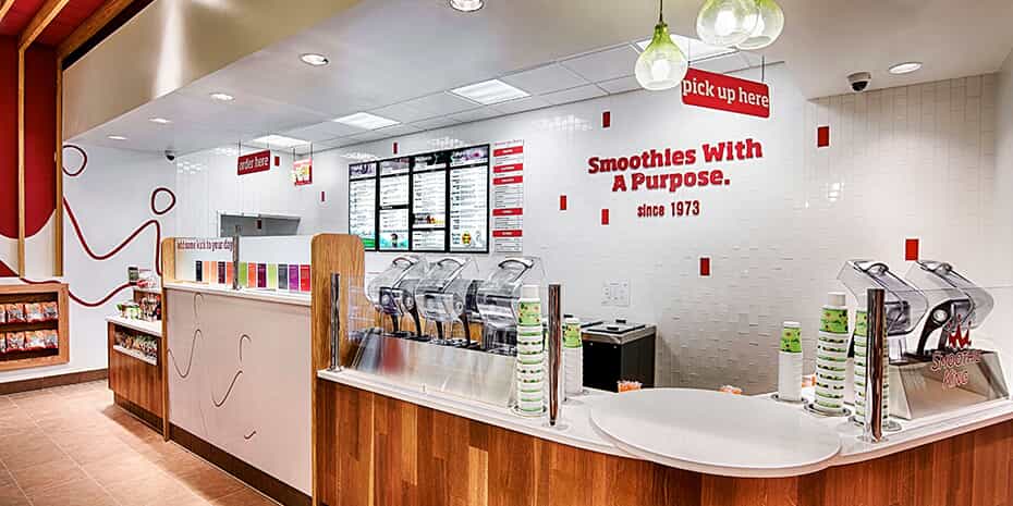 The interior of a fast food restaurant with red and white walls undergoes a transformation as customers trade in their baseball caps for Smoothie King crowns.