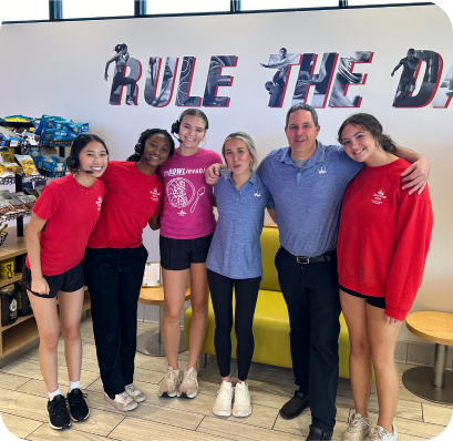 group of people posing for picture inside of smoothie king store